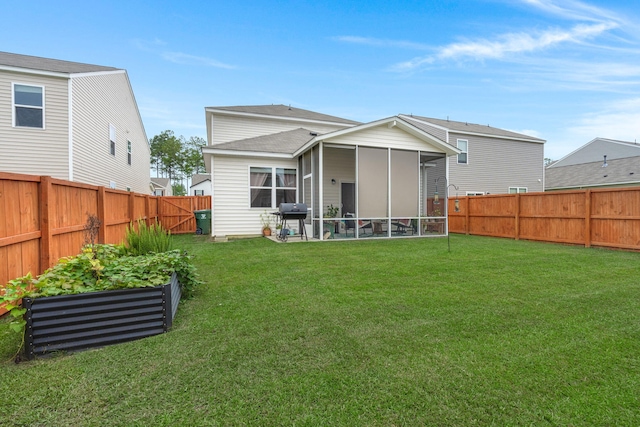 back of house featuring a sunroom and a lawn