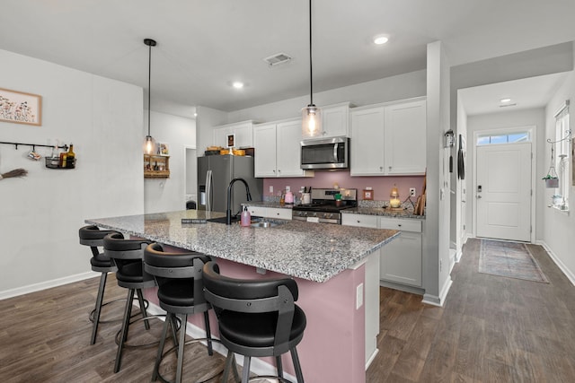 kitchen with white cabinets, stainless steel appliances, sink, and dark wood-type flooring