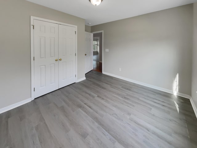 unfurnished bedroom featuring light wood-type flooring and a closet