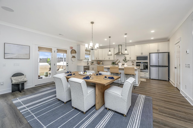 dining area featuring dark wood-type flooring, crown molding, and a notable chandelier