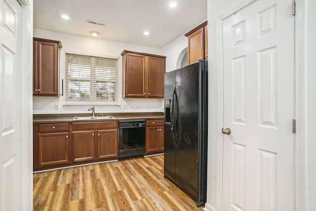 kitchen with light hardwood / wood-style floors, sink, and black appliances