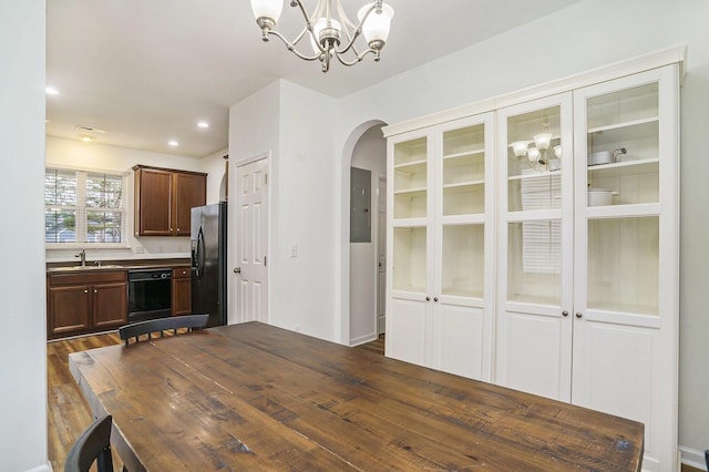 kitchen with sink, an inviting chandelier, black appliances, dark hardwood / wood-style flooring, and decorative light fixtures