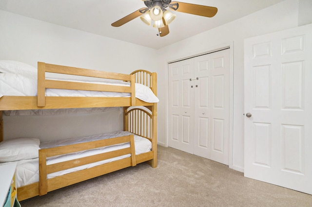 bedroom featuring light carpet, ceiling fan, and a closet