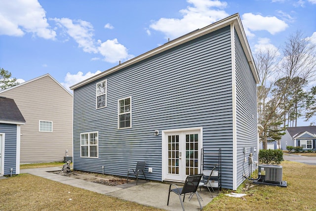 rear view of house with french doors, a yard, central AC unit, and a patio