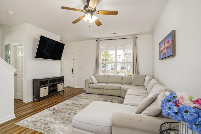 living room featuring ceiling fan and dark hardwood / wood-style floors