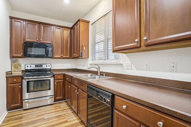 kitchen featuring sink, light hardwood / wood-style floors, and black appliances