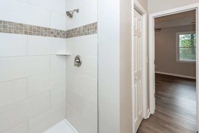 bathroom featuring hardwood / wood-style floors and tiled shower