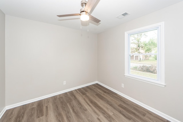 empty room featuring dark wood-type flooring and ceiling fan