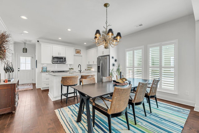 dining space with dark hardwood / wood-style floors and an inviting chandelier