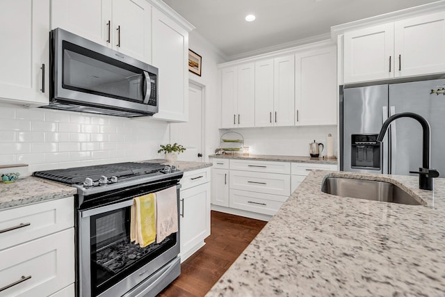 kitchen featuring sink, stainless steel appliances, dark hardwood / wood-style floors, light stone counters, and white cabinets