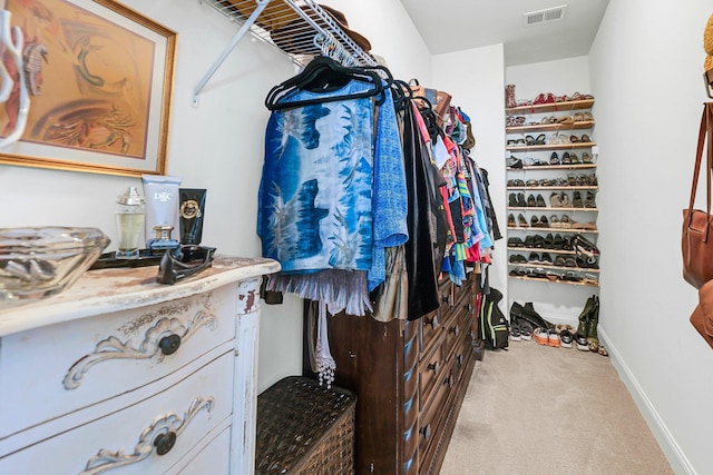 spacious closet featuring light colored carpet