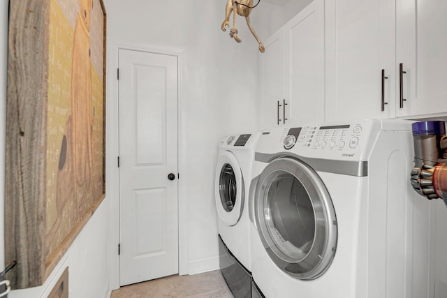 clothes washing area featuring washer and clothes dryer and cabinets