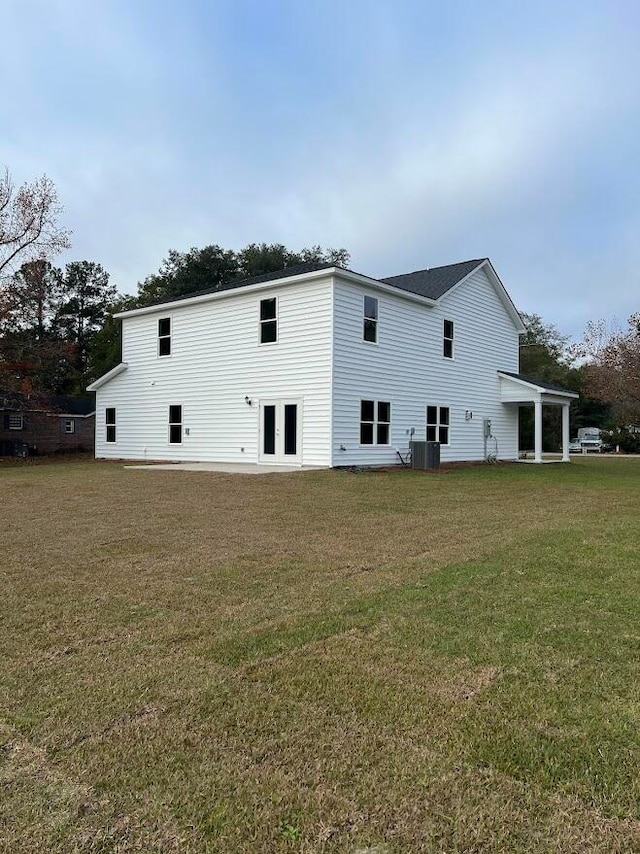 rear view of property with a yard and central AC