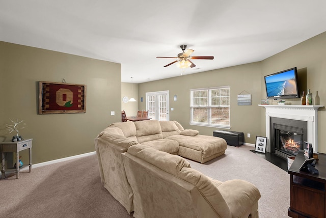 living room with baseboards, a fireplace with flush hearth, and carpet floors