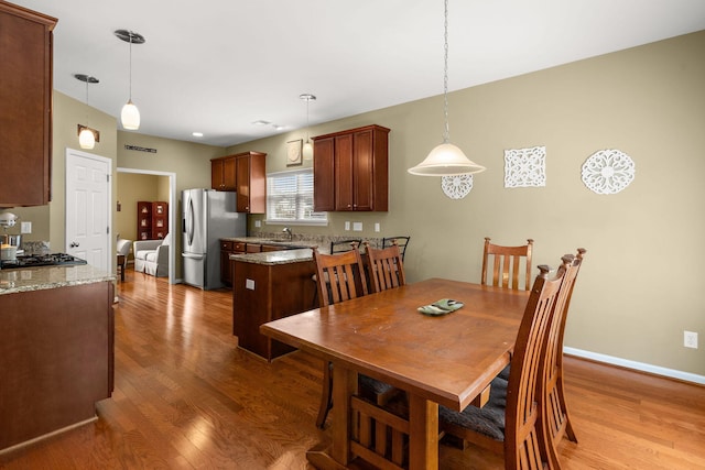 dining area with light wood-style flooring and baseboards