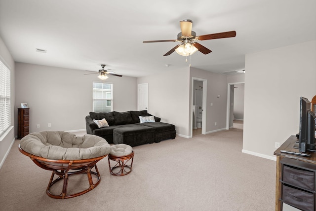 living area featuring visible vents, light colored carpet, baseboards, and ceiling fan