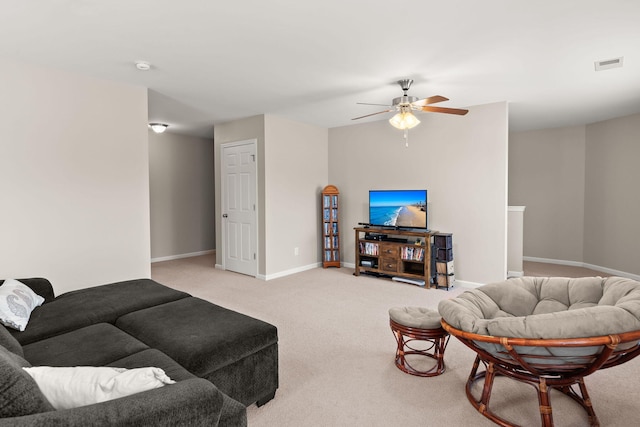 living room featuring visible vents, light colored carpet, baseboards, and ceiling fan