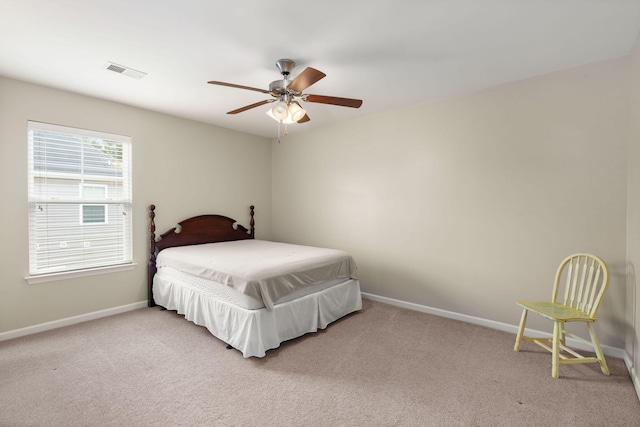 bedroom with visible vents, light colored carpet, a ceiling fan, and baseboards