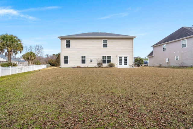 back of property with fence and a lawn