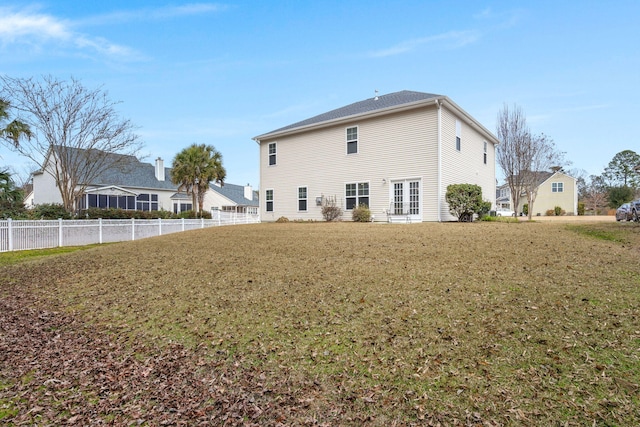 rear view of property with a lawn and fence