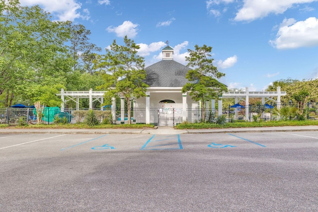 view of building exterior with fence and uncovered parking