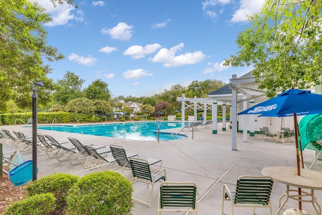 community pool with a patio area and a pergola