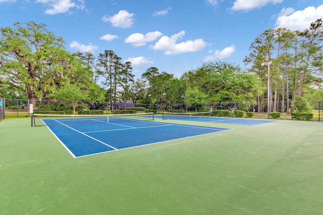 view of tennis court featuring fence