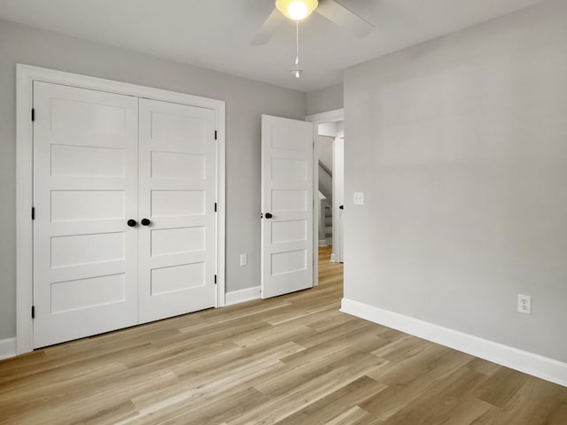 unfurnished bedroom with light hardwood / wood-style flooring, a closet, and ceiling fan