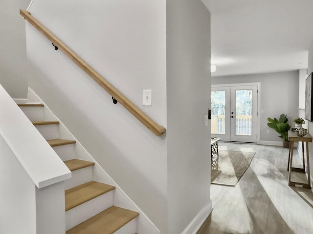 stairway with wood-type flooring and french doors