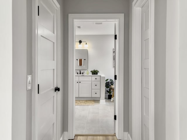 corridor with sink and light tile patterned flooring