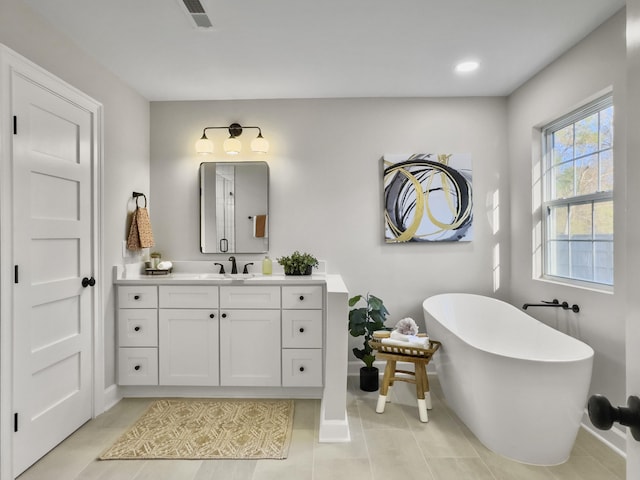 bathroom with vanity, a bath, and tile patterned flooring