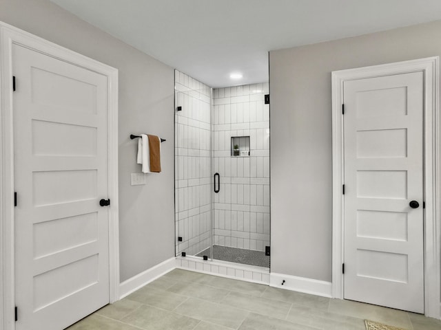 bathroom featuring tile patterned flooring and a shower with shower door