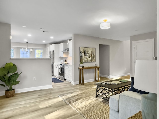 living room with a notable chandelier and light hardwood / wood-style floors