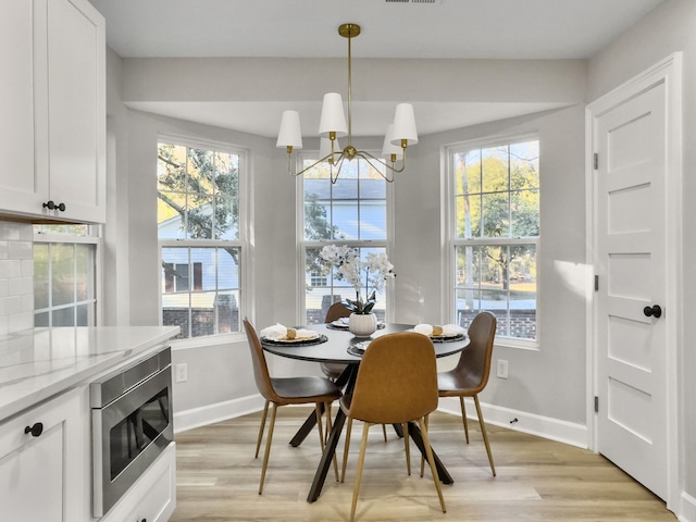 dining room featuring an inviting chandelier and light hardwood / wood-style flooring