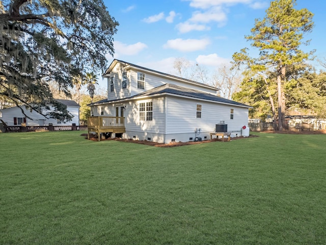 rear view of property featuring a wooden deck and a lawn