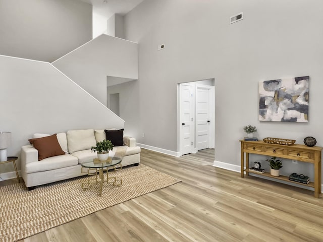 living room with a high ceiling and light wood-type flooring