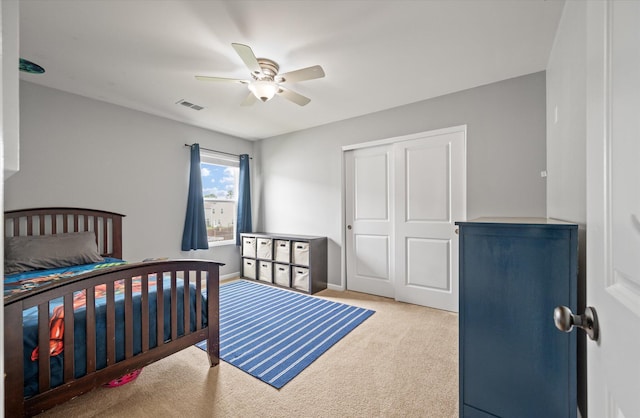 bedroom featuring light carpet, ceiling fan, and a closet