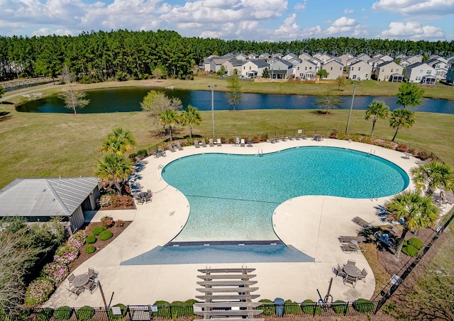 view of pool featuring a water view, a patio, and a lawn