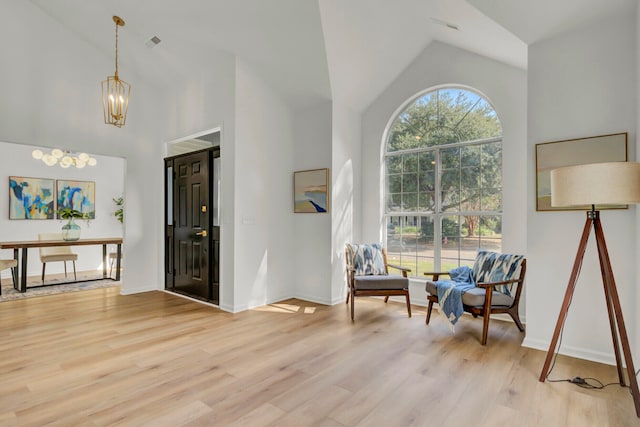 foyer entrance featuring high vaulted ceiling and light wood-type flooring