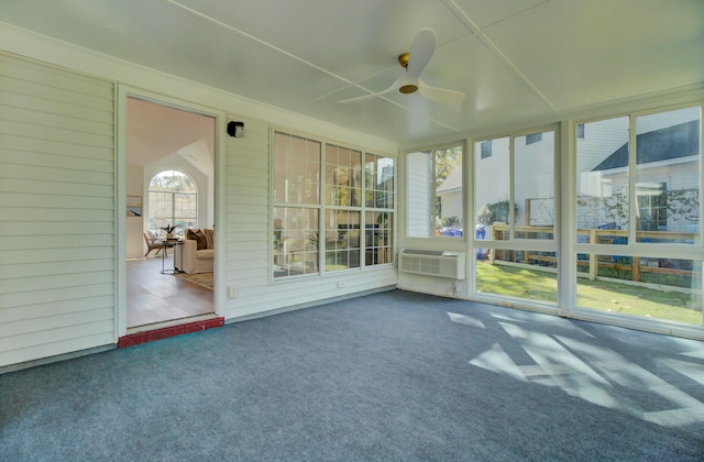 unfurnished sunroom with ceiling fan and a wall mounted AC