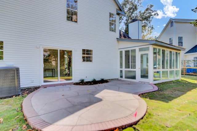 back of house featuring a patio, a sunroom, central AC, and a yard