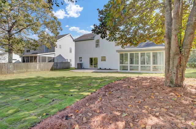 back of house featuring a lawn, central AC, a sunroom, and a patio area