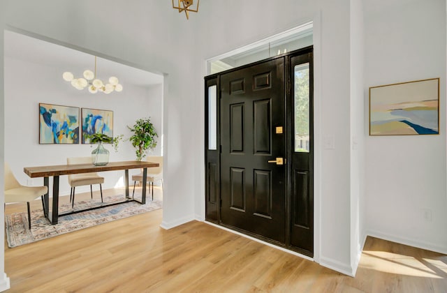 entryway with hardwood / wood-style floors and an inviting chandelier