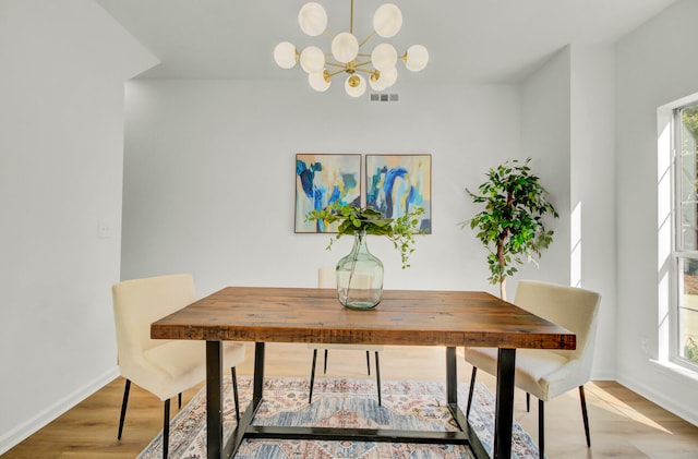 dining area featuring a chandelier, hardwood / wood-style flooring, and a healthy amount of sunlight