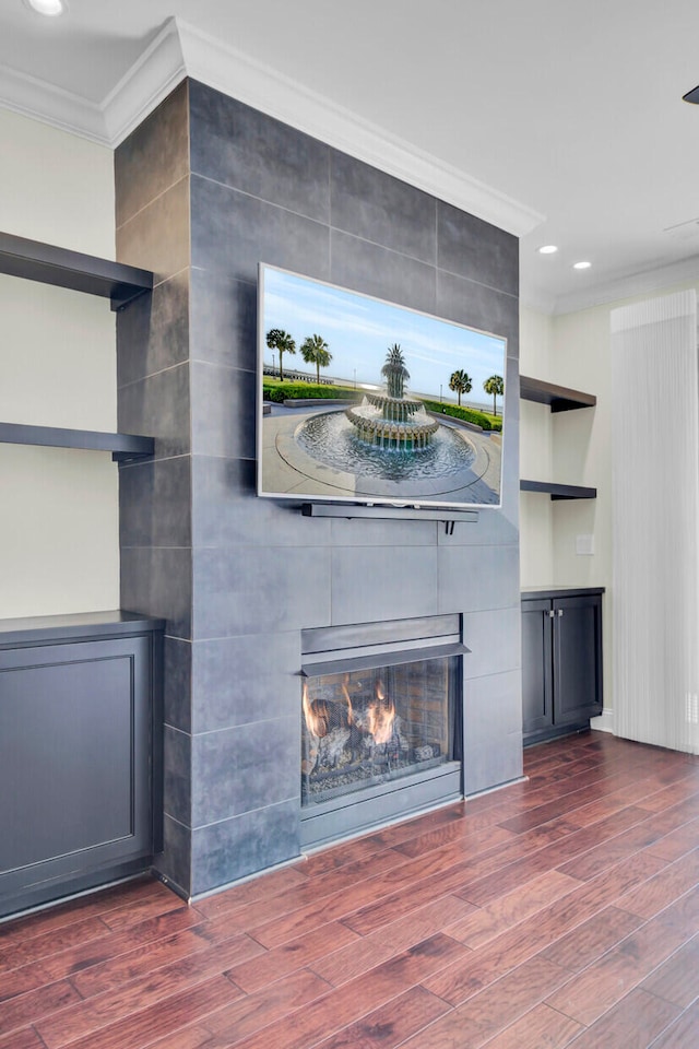 unfurnished living room featuring a fireplace, ornamental molding, tile walls, and dark wood-type flooring