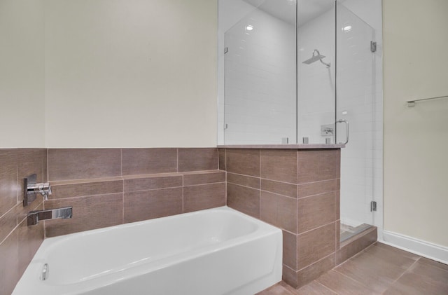 bathroom featuring tile patterned floors, independent shower and bath, and tile walls