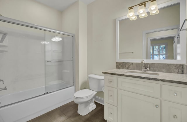 full bathroom featuring vanity, bath / shower combo with glass door, and toilet