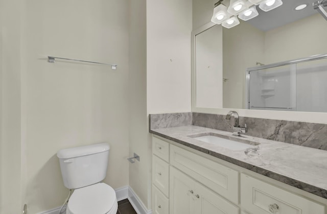 bathroom with vanity, a shower with shower door, and toilet