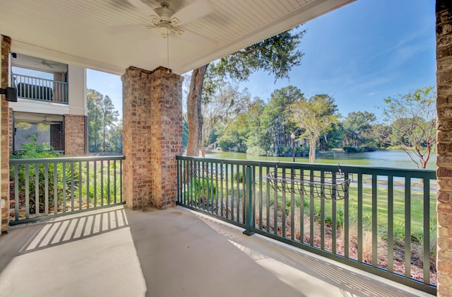 balcony featuring ceiling fan and a water view