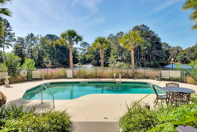 view of pool featuring a patio and a water view